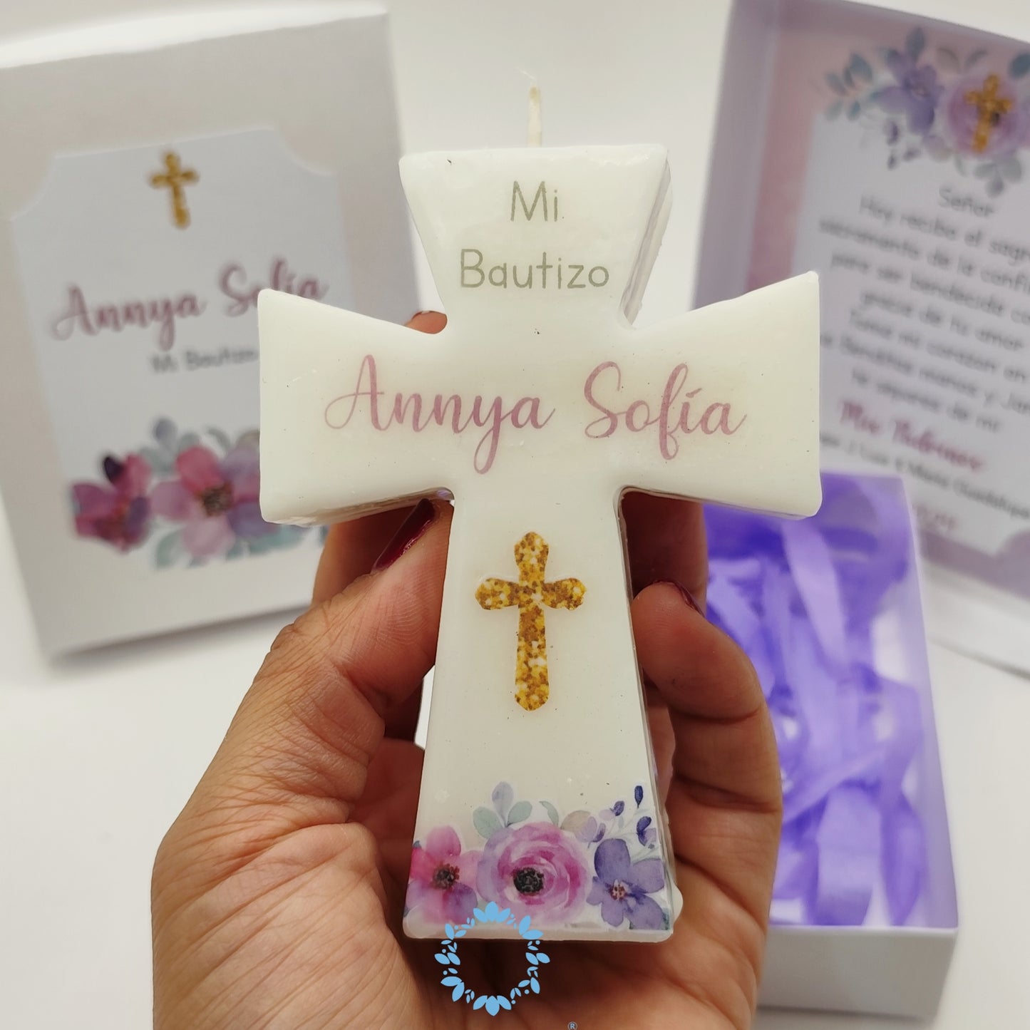 Vela de cruz en caja de cartón. Diseño flores moradas